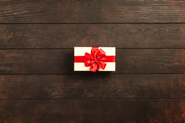 Človek izroča zavito darilo z ljubeznijo in nasmehom